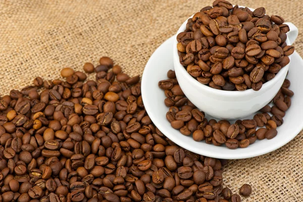 Taza blanca con granos de café — Foto de Stock