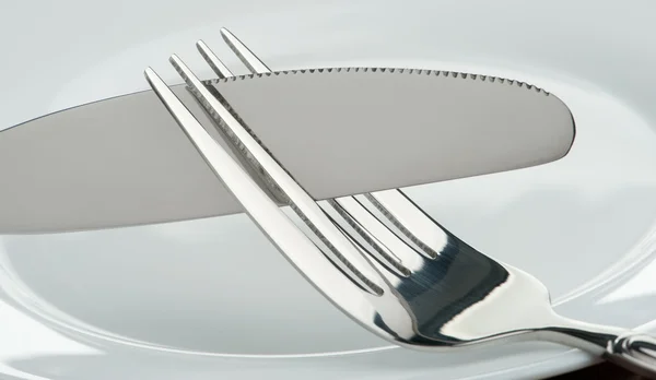 Нож и вилка на тарелке — стоковое фото