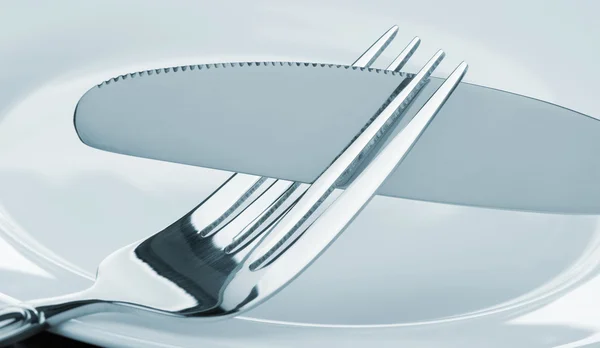 Knife and fork on a plate — Stock Photo, Image