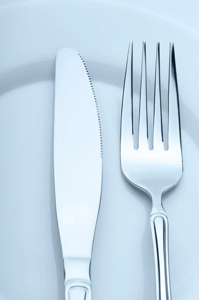 Cuchillo y tenedor en un plato —  Fotos de Stock