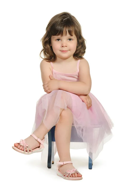 Hübsch sitzt das kleine Mädchen auf einem Hocker — Stockfoto