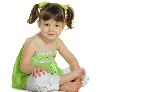 Hübsch sitzt das kleine Mädchen auf dem weißen — Stockfoto