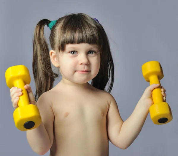 Kleines Mädchen mit Hanteln grauen Bakcground — Stockfoto