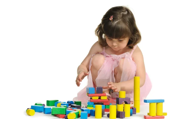 The lovely little girl plays colour wooden cubes — Stock Photo, Image