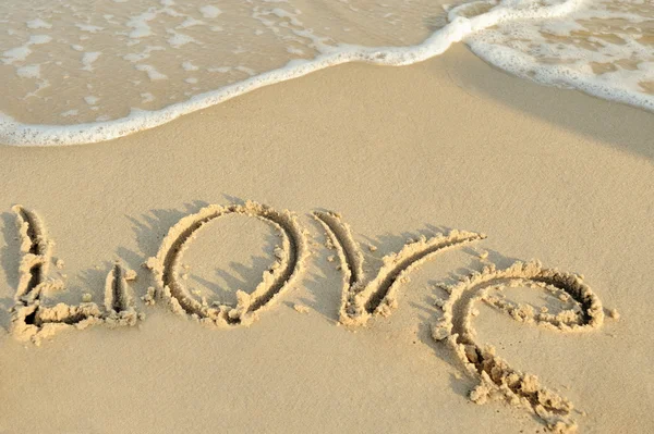 Inscription "love" on sand — Stockfoto