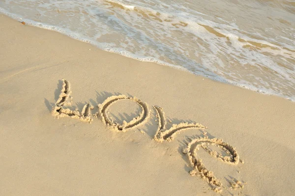 Inscription "love" on sand — 스톡 사진