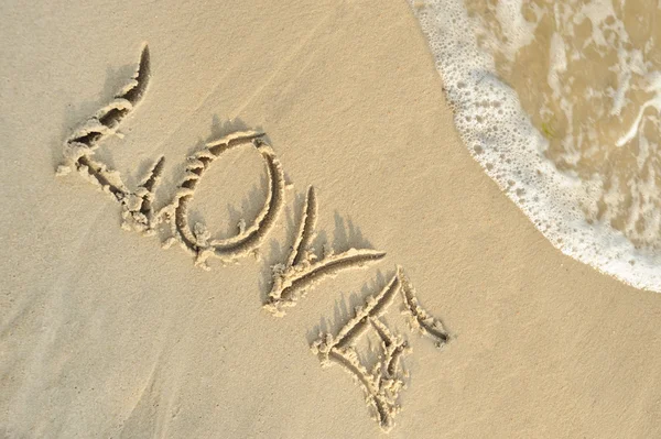 Inscription "love" on sand — 스톡 사진