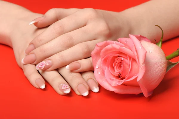 Manikűr. női kezek, a vörös háttérben — Stock Fotó