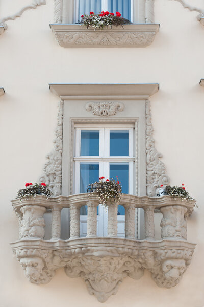 Facade of a building with a balcony and flowers. The building is constructed 1850-1890