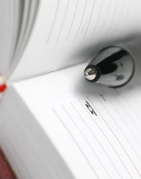 Um alicate e uma caneta. O caderno com uma caneta esferográfica preta — Fotografia de Stock