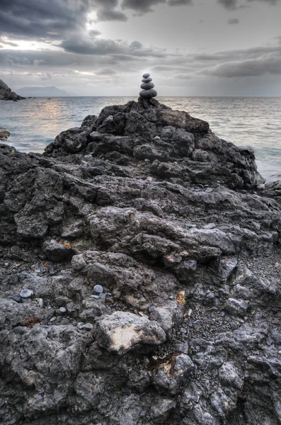 Камушек и камни на фоне драматического неба — стоковое фото