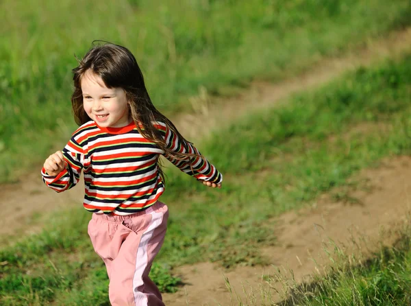 De lopende meisje op een groen veld — Stockfoto