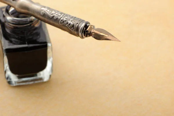 Feather quill and inkwell on an old paper — Stock Photo, Image