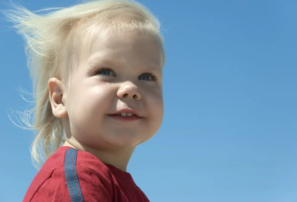 Mavi gözlü sarı saçlı bir rüzgarla gelişmekte olan çocukla — Stok fotoğraf