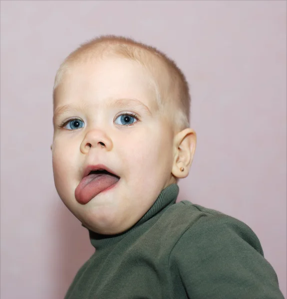 Mavi gözlü çocuk dilini koymak — Stok fotoğraf