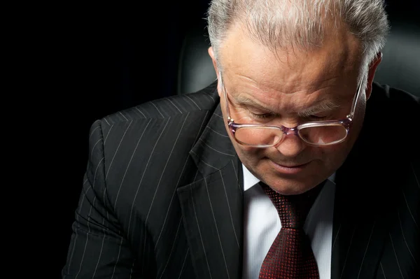 stock image The elderly man in eyeglases reads the document