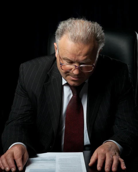 The elderly man in eyeglases reads the document — Stock Photo, Image