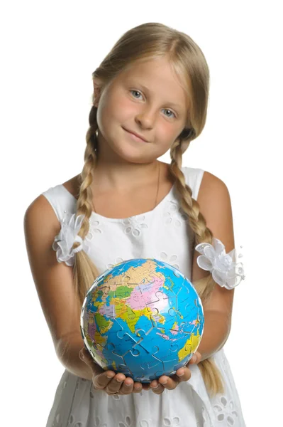 Stock image The girl holds the globe collected from puzzle in hands. Selecti