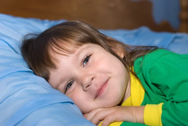 Het kleine meisje op een bed — Stockfoto
