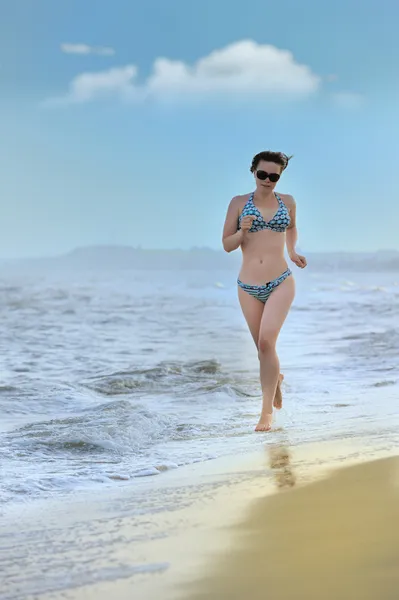 Девочка, бегущая по берегу моря — стоковое фото