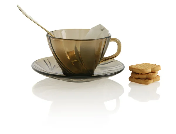 Copo transparente de vidro vazio com colher, biscoito, chá de pacote anf — Fotografia de Stock