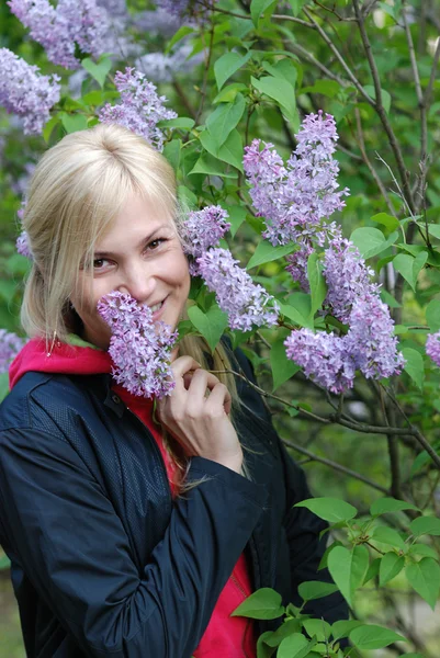 A menina bonita perto de um arbusto de um lilás — Fotografia de Stock