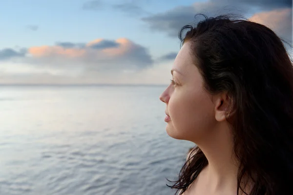 Die attraktive Frau am Meeresufer und der schöne Farbenhimmel — Stockfoto