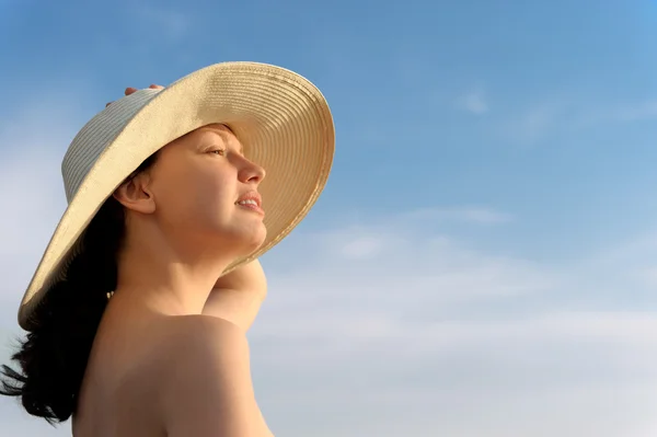 La chica en un sombrero contra el cielo azul —  Fotos de Stock