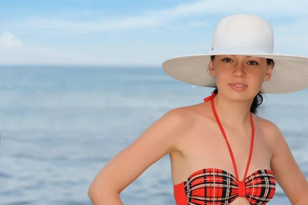 La muchacha en el sombrero contra el mar y el cielo azul —  Fotos de Stock