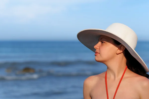 La muchacha en el sombrero contra el mar y el cielo azul —  Fotos de Stock