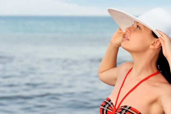 La muchacha en el sombrero contra el mar y el cielo azul — Foto de Stock