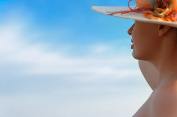 A menina de chapéu contra o céu azul — Fotografia de Stock