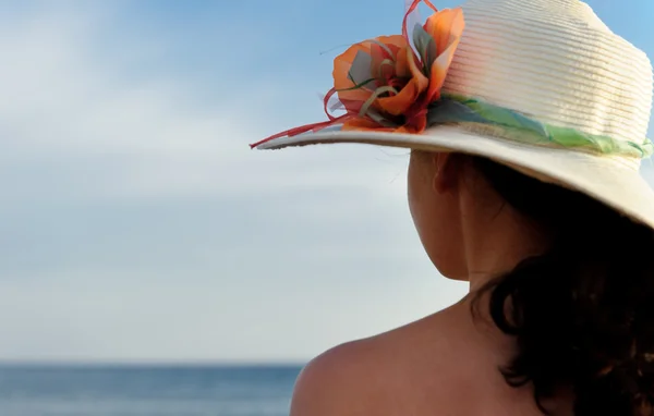Flickan i ett hat mot den blå himlen — Stockfoto
