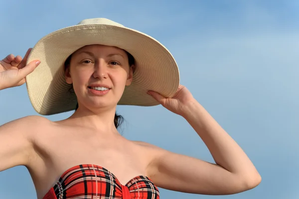 La chica en un sombrero contra el cielo azul —  Fotos de Stock
