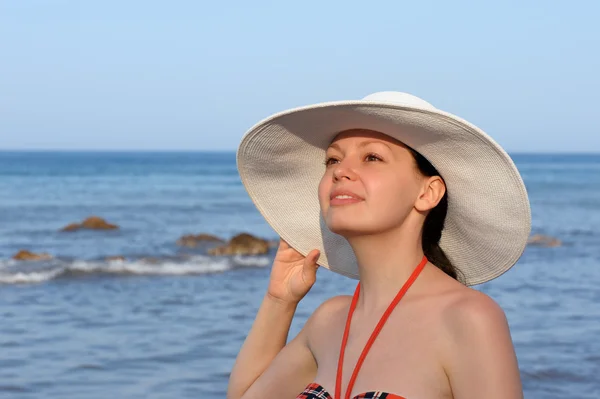 Девушка в шляпе против моря и голубого неба — стоковое фото