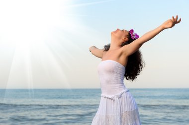The woman in a white sundress on seacoast with open hands clipart