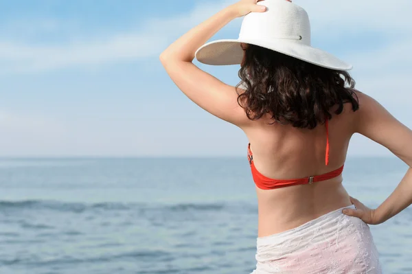 Žena na pobřeží moře v klobouku — Stock fotografie