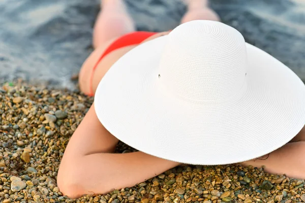 De vrouw op de kust van de zee in een hoed — Stockfoto