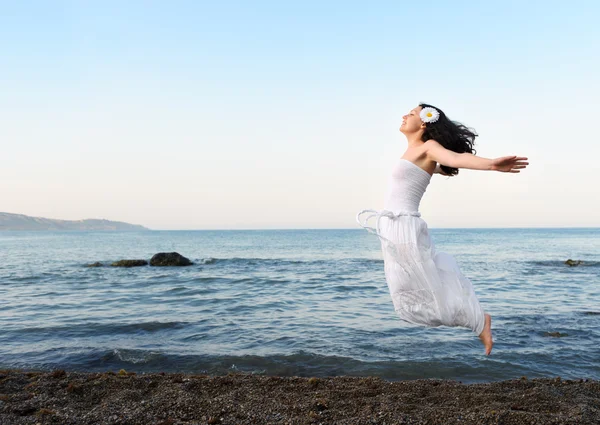 The young woman jumps on seacoast — Stock Photo, Image
