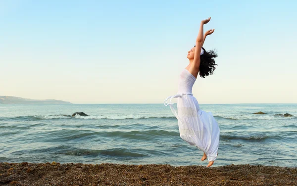 De jonge vrouw springt op Zeekust — Stockfoto