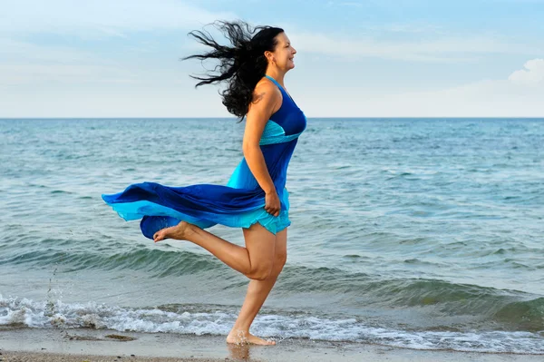 Женщина бежит по берегу моря — стоковое фото