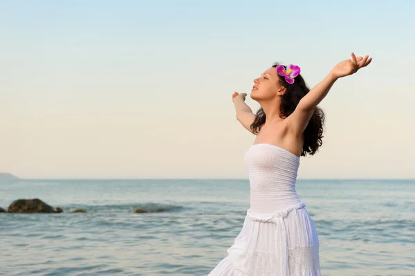 Žena v bílé letní šaty na mořského pobřeží s otevřít rukou — Stock fotografie