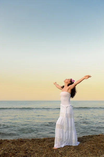La mujer en el vestido blanco a la orilla del mar con las manos abiertas — Foto de Stock