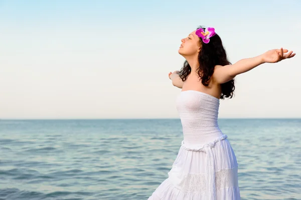 The woman in a white sundress on seacoast with open hands — Stock Photo, Image