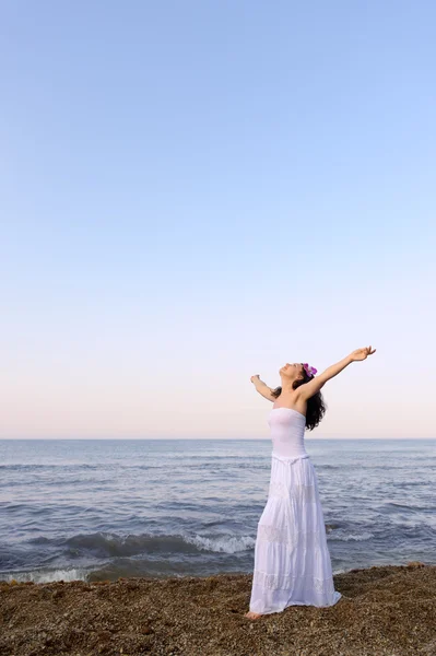 Жінка в білому сонечку на морі з відкритими руками — стокове фото