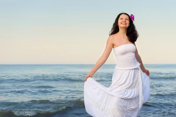 Die Frau im weißen Kleid am Ufer des Meeres. — Stockfoto
