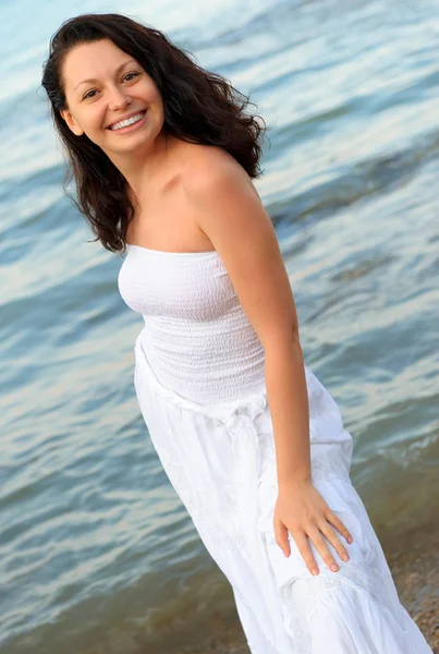 海岸に白いサンドレスの女性. — ストック写真
