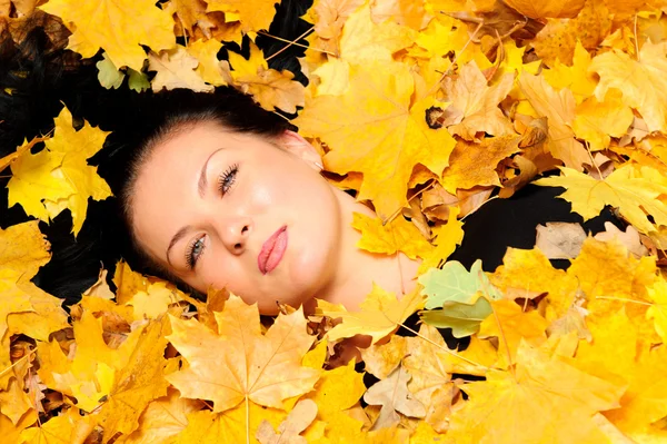 A mulher atraente encontra-se na folha do outono — Fotografia de Stock