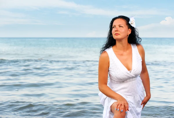 Kvinnan i en vit sundress på seacoast. — Stockfoto