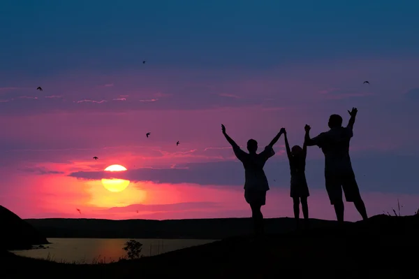 A família de três pessoas acolhe o pôr-do-sol — Fotografia de Stock